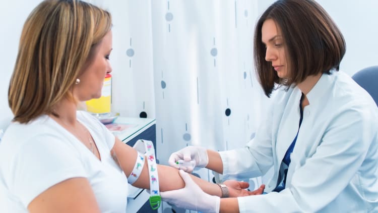 female health care worker drawing blood from a female patient.